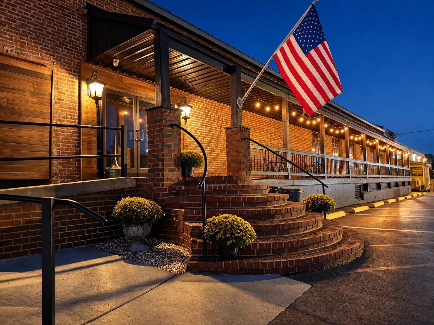 Night view of the Depot Square Events porch with string lights and the American flag